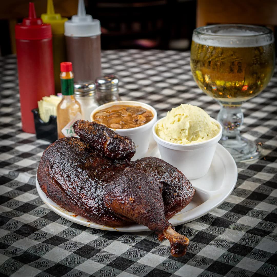 Half a smoked chicken on a plate with beans and potato salad at Sammies Bar-B-Q in Fort Worth, TX